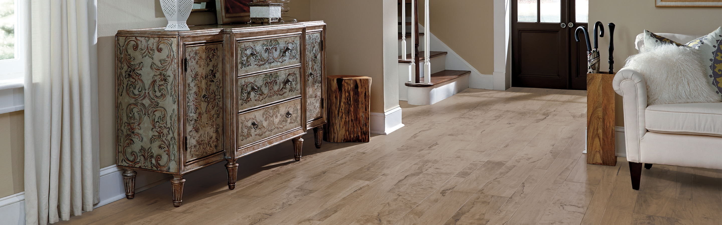 Rustic hardwood floors in living room entryway with stairs, white couch 