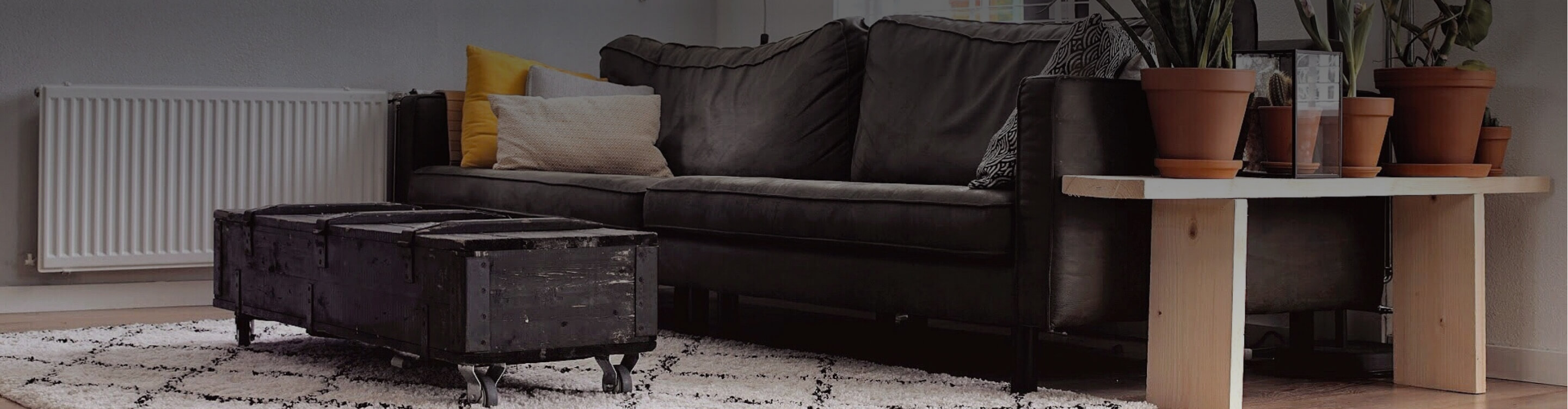 Black and white pattern rug under grey sofa and coffee table.